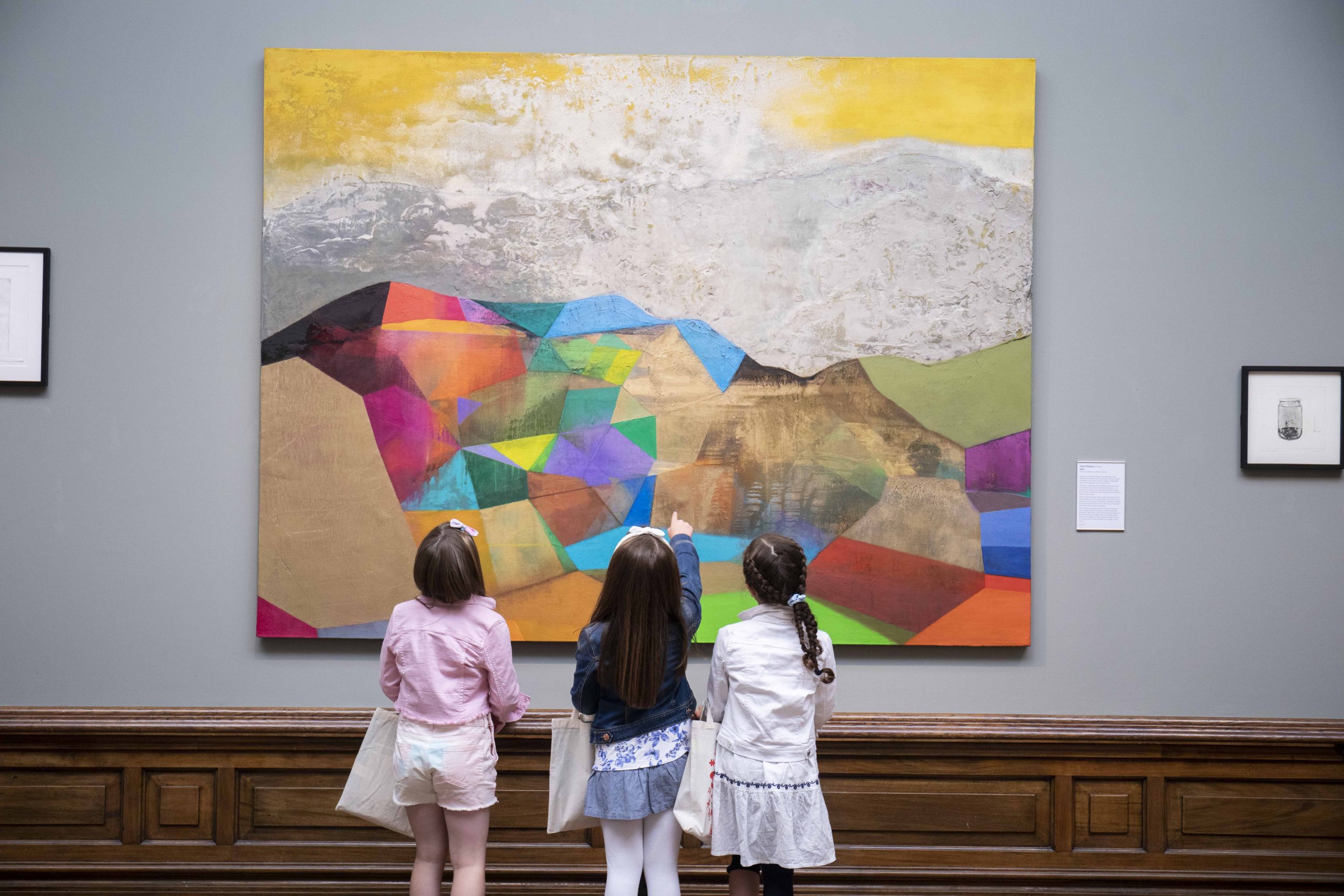 Three little girls examining a piece of artwork in the Crawford Art Gallery